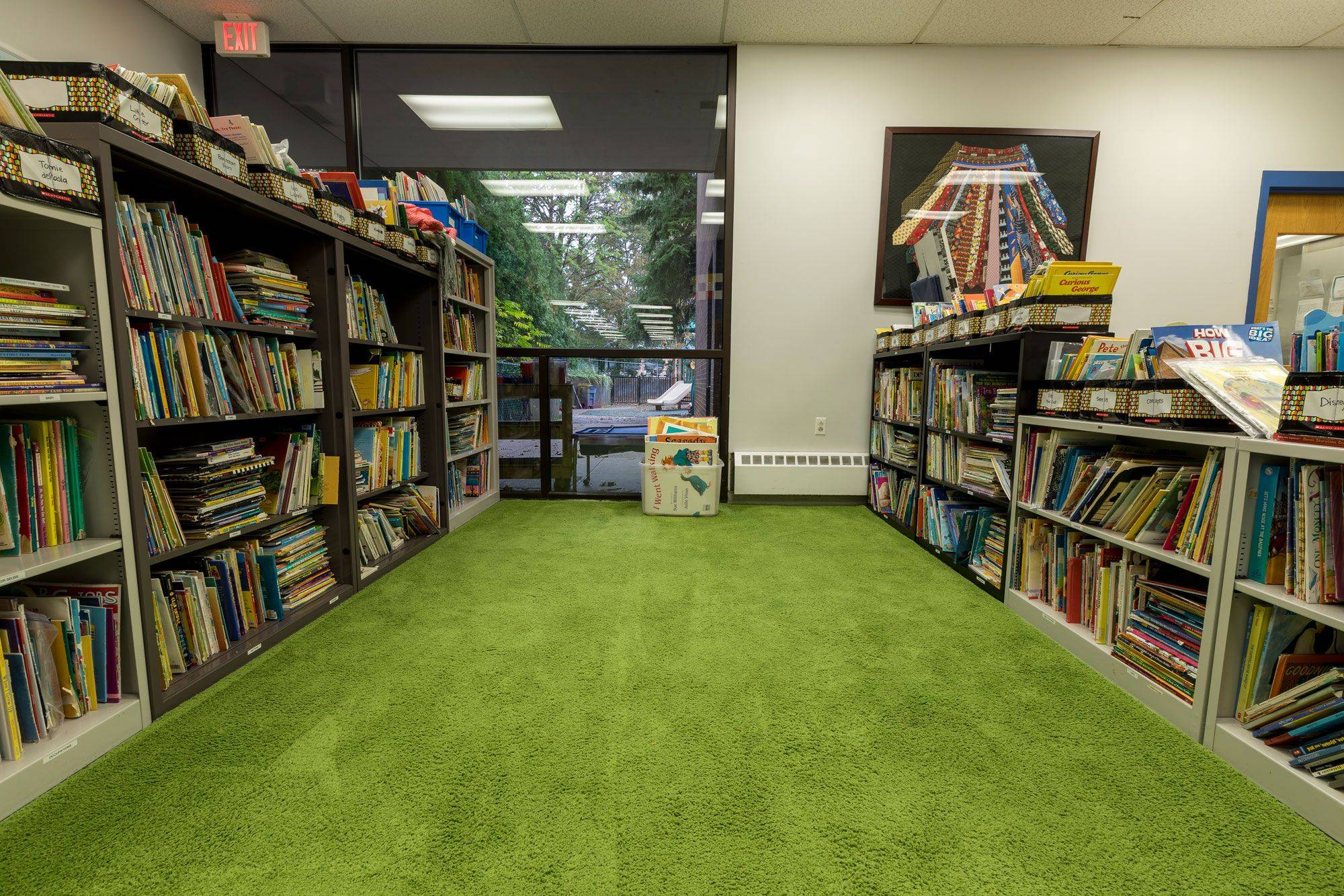 Photo of a carpeted space surrounded by shelves of books at Lakewood Child Care Center