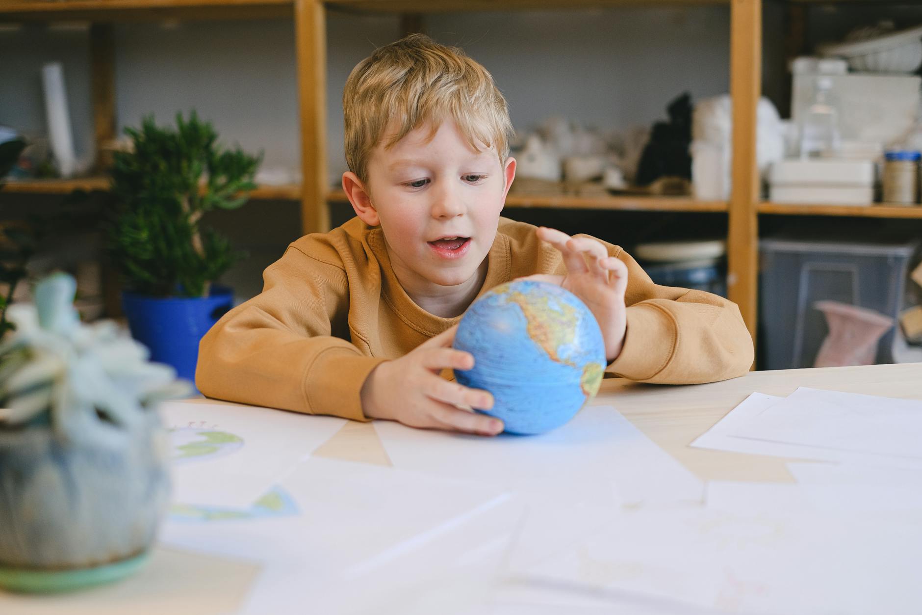 a little boy looking at a globe