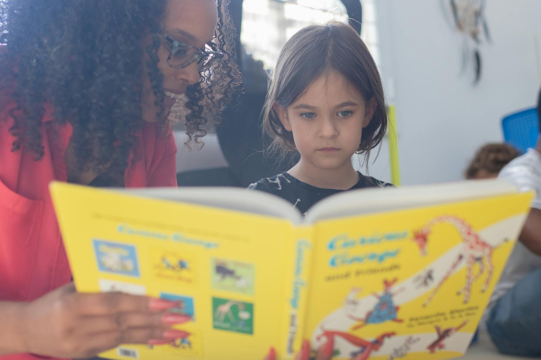 a teacher reading story to a girl