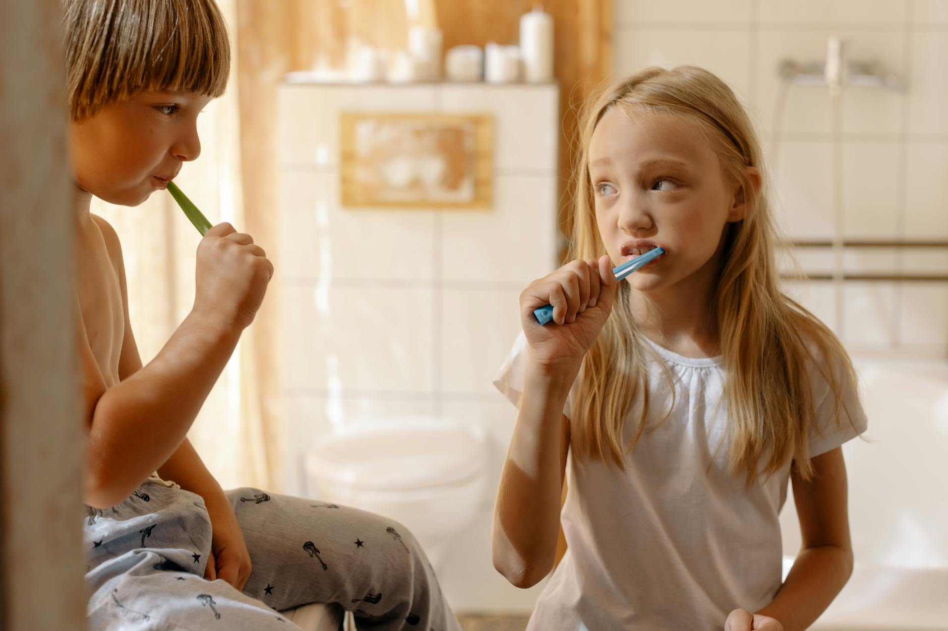siblings brushing their teeth