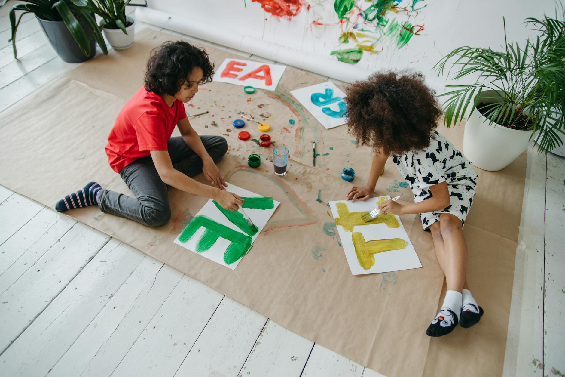 a boy and girl painting on floor