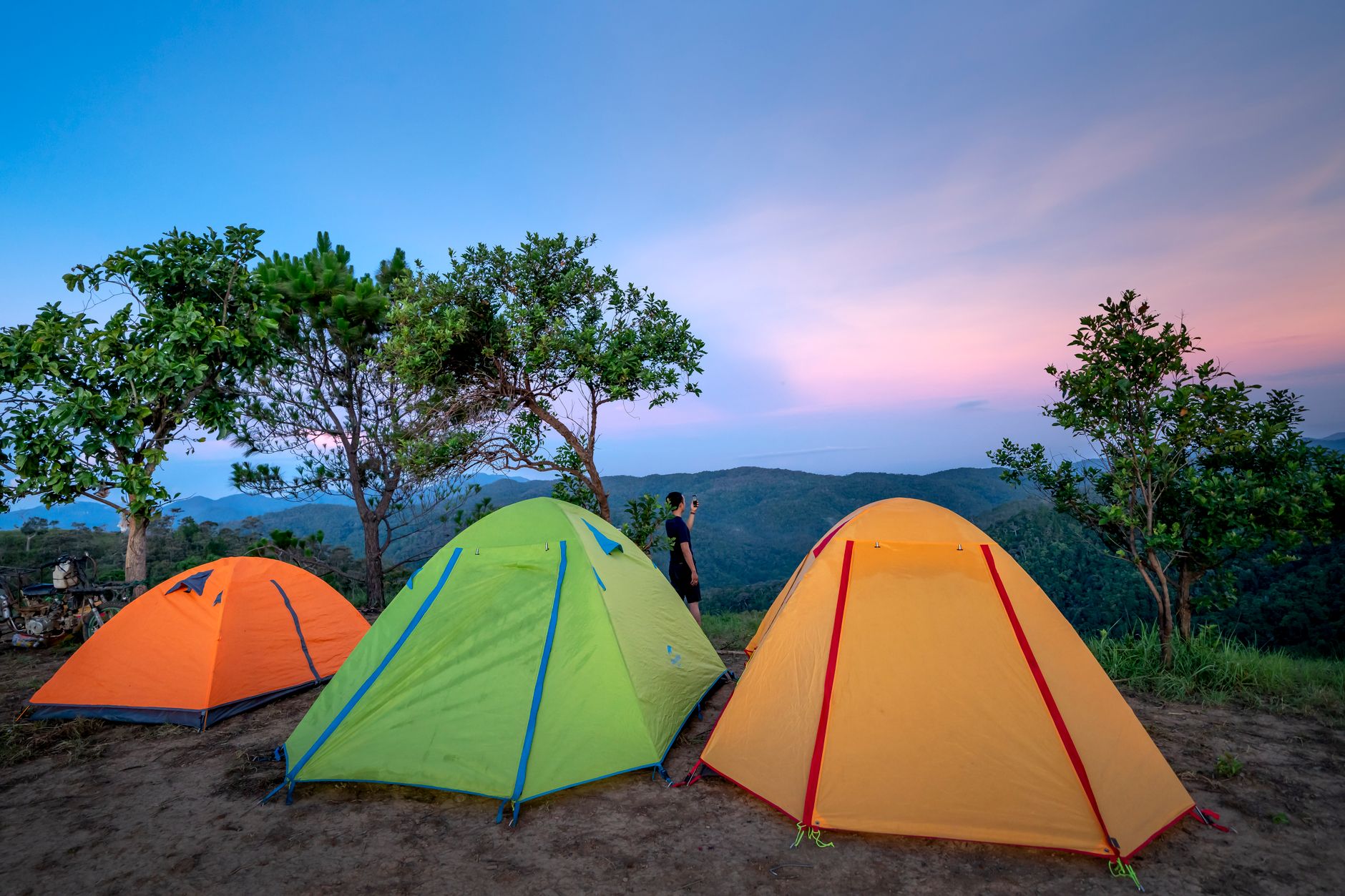 multicolored camping tents on mountain peak during sundown