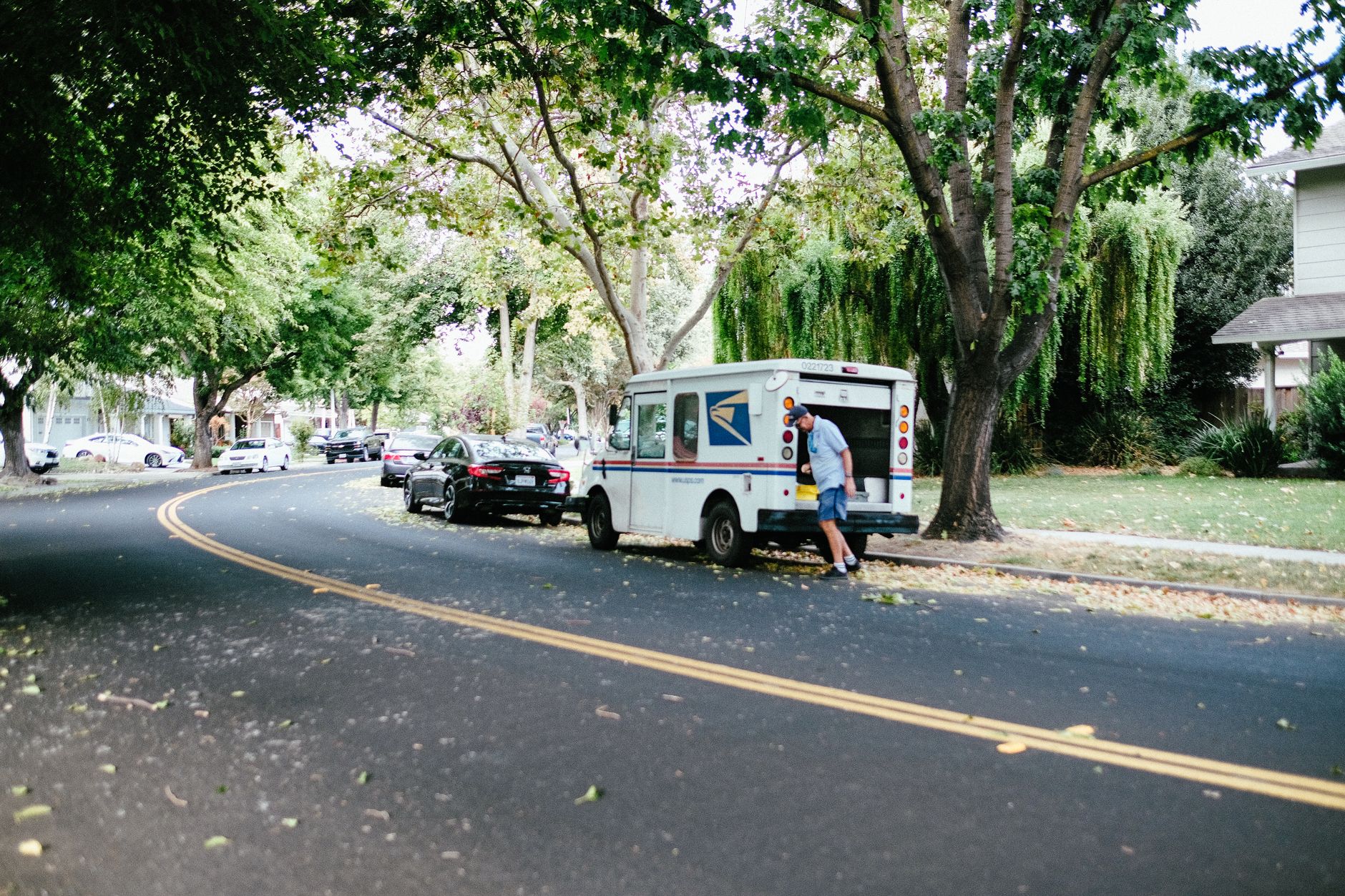 a man walking beside usps mail van