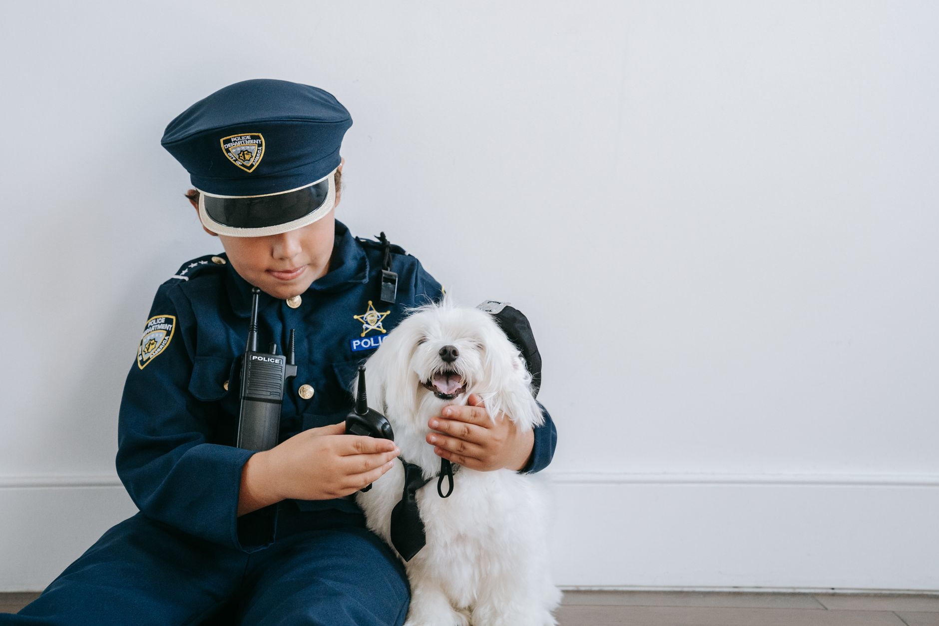 a boy in a police costume playing with his dog